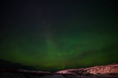 Tepeler, berrak yıldızlı gökyüzü ve renkli kuzey ışıkları, inanılmaz bir doğa olayı.