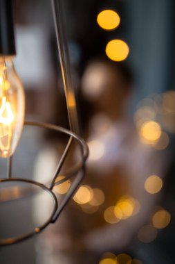 Sarı ampuller ve arka planda Bokeh 'de birbirine aşık bir çifti kucaklıyor