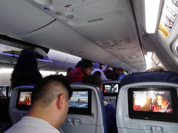 Aviões Delta Jet vista interior enquanto as pessoas se preparam para desembarcar — Fotografia de Stock