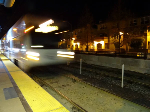 Blur of VTA transit lightrail train arrives into station at nigh — Stock Photo, Image