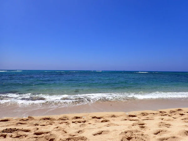 Sanfte Wellenrunde am Strand mit Booten am Ozeanhorizont — Stockfoto