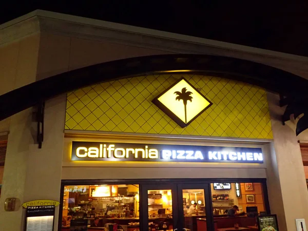Califórnia Pizza Cozinha Logo brilha acima do estabelecimento de alimentos — Fotografia de Stock