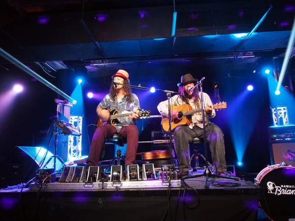 Tavana und Keith Batlin spielen Gitarre und singen auf der Bühne — Stockfoto