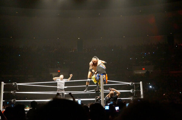 WWE wrestlers Karl Anderson setup a superplex to Uso on top rope