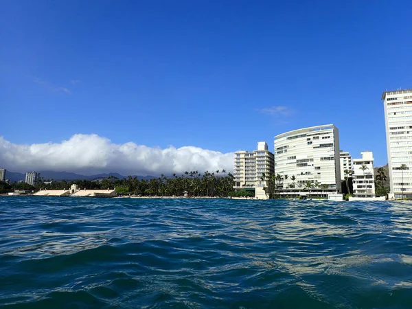 Agua ondulada en el océano frente a la playa de Kaimana con hoteles y condominios — Foto de Stock