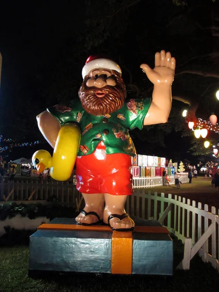 Hawaiianische Weihnachtsmänner halten Gummientchen in den Händen, während er winkt — Stockfoto