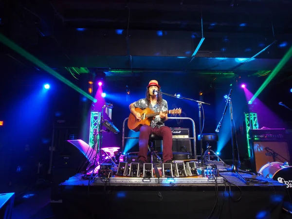 El músico Tavana toca la guitarra y canta en el escenario — Foto de Stock