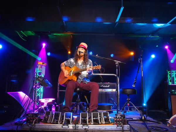 El músico Tavana toca la guitarra y canta en el escenario — Foto de Stock