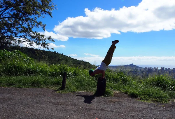 Man does Mayurasana or Peacock Pose on tree stump in the mountai — Stock Photo, Image