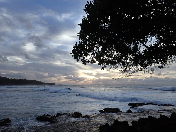 Schöner Sonnenuntergang über dem Ozean mit Person, die Welle reitet — Stockfoto