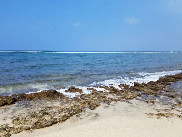 Rotsachtig strand met ondiepe golvende Oceaan wateren van Camp Mokuleia Beac — Stockfoto