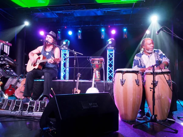 El músico Tavana toca la guitarra y canta con Leon Mobley tocando el dr. — Foto de Stock