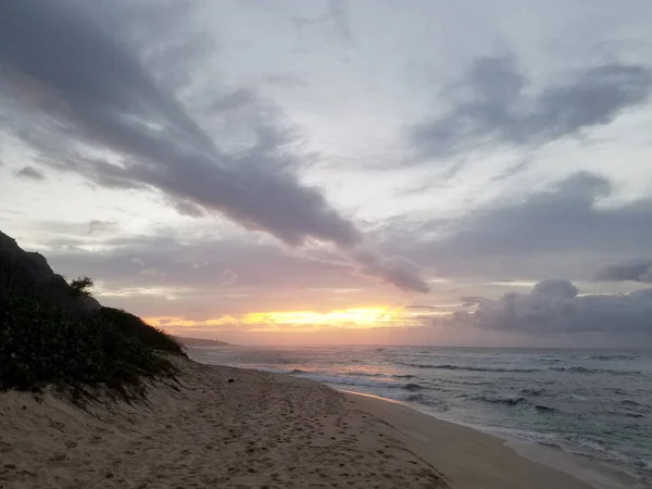 Puesta de sol sobre el océano con olas moviéndose a la orilla —  Fotos de Stock