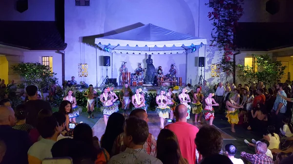 Hula dancers dance as musicians play on stage with crowd watchin — Stock Photo, Image