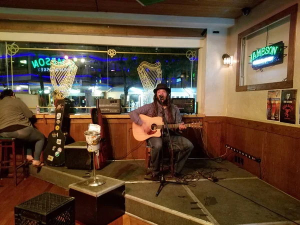 Регги музыкант Кит Батлин поет и играет на гитаре, когда он играет — стоковое фото
