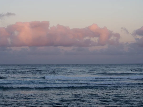 Hermosa rosa y púrpura amanecer sobre el océano con olas rodando — Foto de Stock