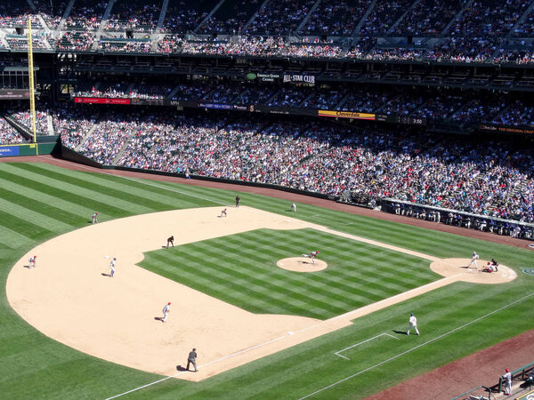 Cardinals Pitcher steps forward to throw pitch to Mariners batte