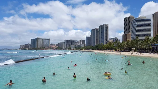 People play in the protected water and hang out on the beach in — Stock Photo, Image