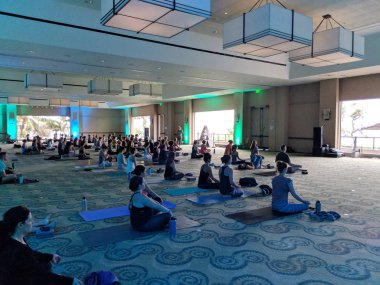 İnsanlar oturup kapalı yoga dersinde