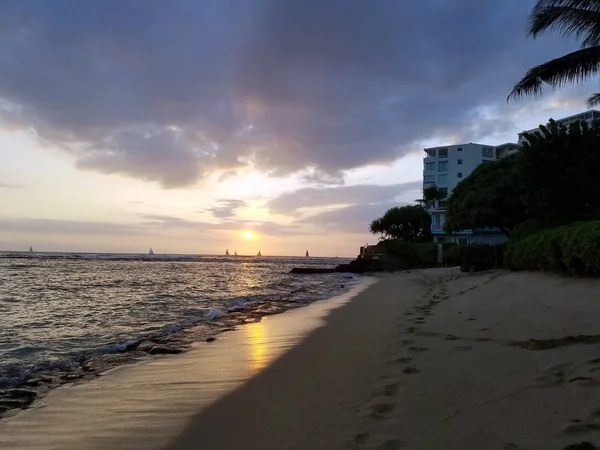 Puestas de sol sobre las aguas de Waikiki mientras las olas llegan a la costa en Makalei —  Fotos de Stock