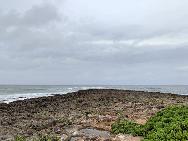 Rocky shoreline with napaka leading to the ocean — Stock Photo, Image