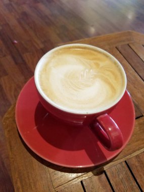 Kırmızı fincan Cappuccino üzerinde köpük bir yaprak desenli tabak