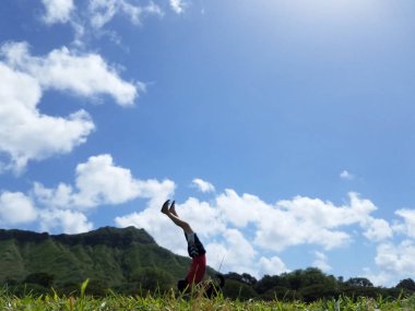 Adam Handstanding Diamond Head ve Oahu, Hawaii mesafe bulutlarda ile gün boyunca Kapiolani Park.