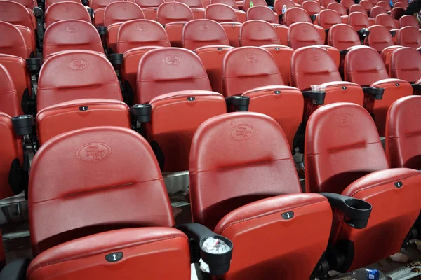 Fileiras de assentos de estádio vermelhos vazios que vão para cima — Fotografia de Stock
