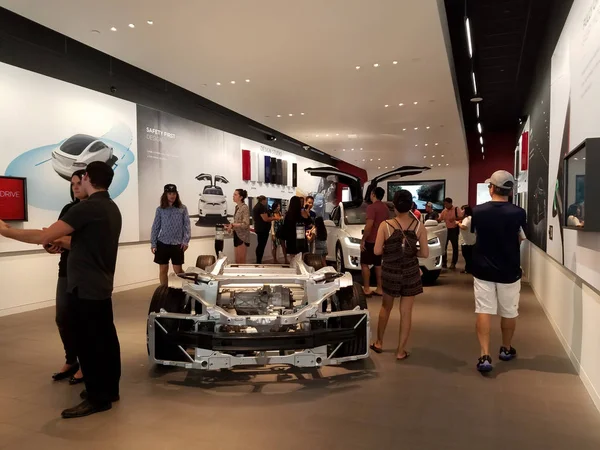 La gente mira los coches dentro de Tesla Store —  Fotos de Stock