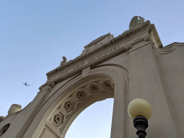 Waikiki Natatorium War Memorial za soumraku s letadlem v sk — Stock fotografie