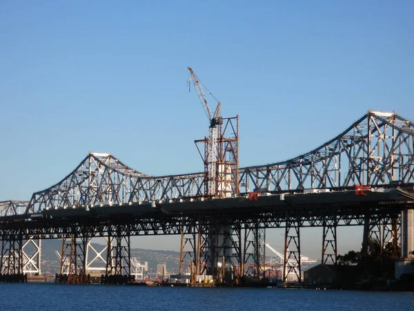 Grúa grande trabaja en la sección de construcción del nuevo puente de la bahía — Foto de Stock