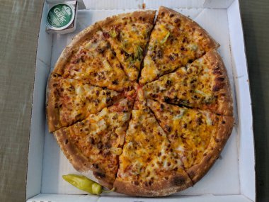 Honolulu - February 18, 2018: Large Papa John Pizza with mix of toppings with Garlic Sauce and Hot pepper on the side.