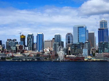 Downtown Seattle, Washington, USA - May 18, 2019: Scene of the Waterfront Park with Ferris Wheel, Pier 56, and cityscape.