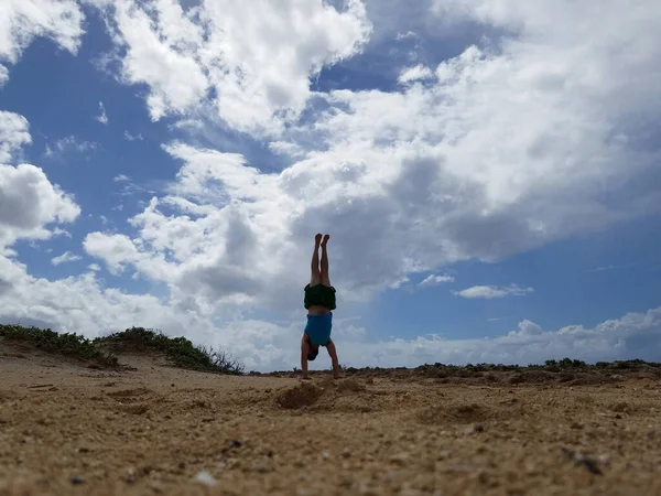 夏威夷瓦胡岛北岸 人们在沙滩上手倒立 天空中飘扬着云彩 — 图库照片