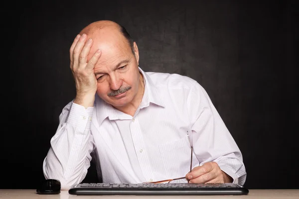 Elderly man looking away thoughtfully, pondering the problem or task — Stock Photo, Image