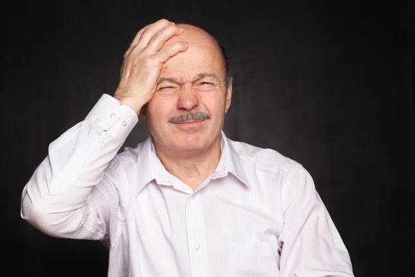 Older man in white shirt hugged his head, wincing. — Stock Photo, Image