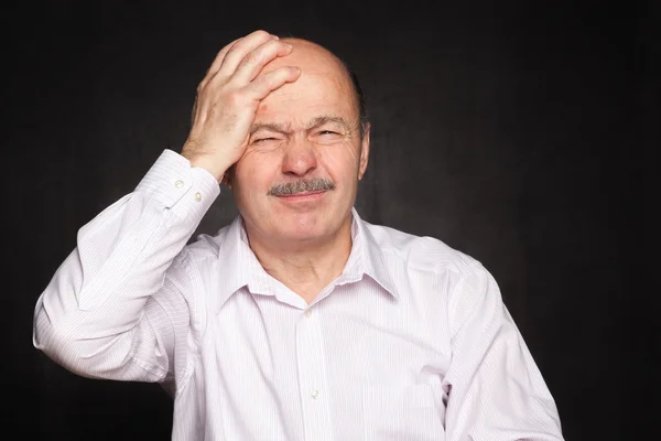 Älterer Mann in weißem Hemd umarmte seinen Kopf und zuckte mit den Schultern. — Stockfoto