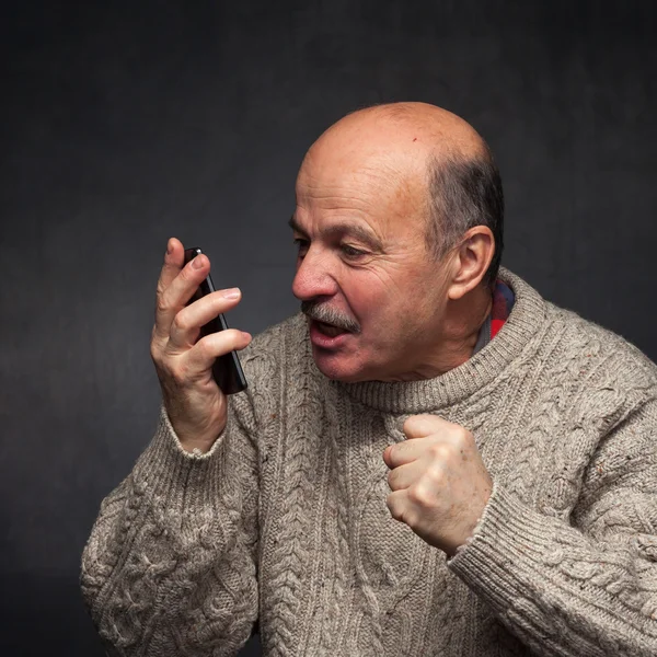 Homem mais velho grita para o telefone com raiva . — Fotografia de Stock