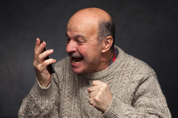 Homem mais velho grita para o telefone com raiva . — Fotografia de Stock