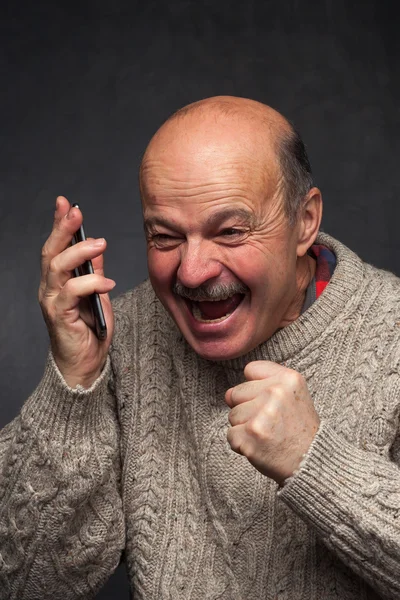 Oudere man schreeuwt in de telefoon in woede. — Stockfoto