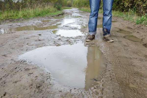 Человек в грязной обуви, стоящий в грязи — стоковое фото