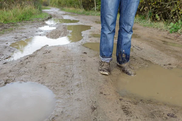 Man in dirty shoes standing in the mud — Stock Photo, Image