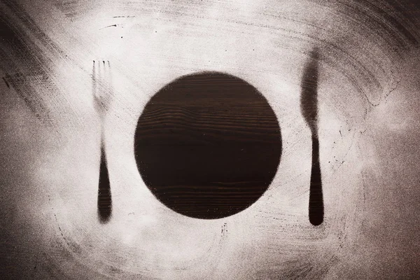 Plaque de silhouette, fourchette et couteau sur fond bois noir — Photo