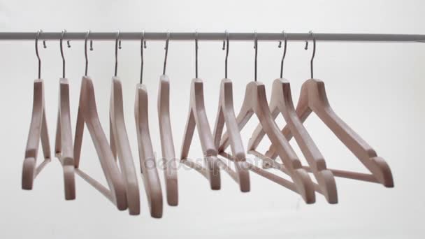 Number of empty hangers after a major sell-off in the store. Wooden bright hangers for coat and dress on the rack — Stock Video