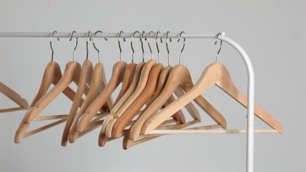 Het aantal lege hangers na een grote sell-off in de winkel. Houten heldere hangers voor jas en jurk op de pijnbank — Stockvideo