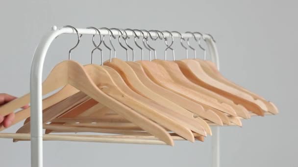 Het aantal lege hangers na een grote sell-off in de winkel. Houten heldere hangers voor jas en jurk op de pijnbank — Stockvideo