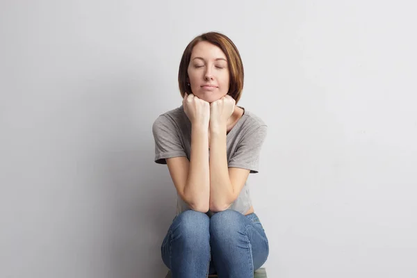 Mädchen sitzt mit den Händen am Kinn — Stockfoto