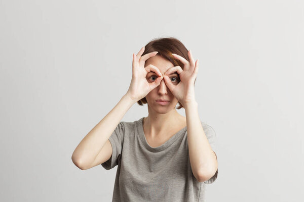 девушка, держащая пальцы рядом с глазами
