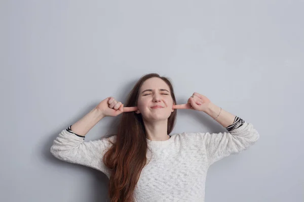 Woman plugging ears — Stock Photo, Image