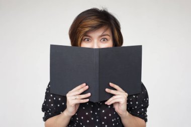 Kitap ile yüzünü kaplayan kız